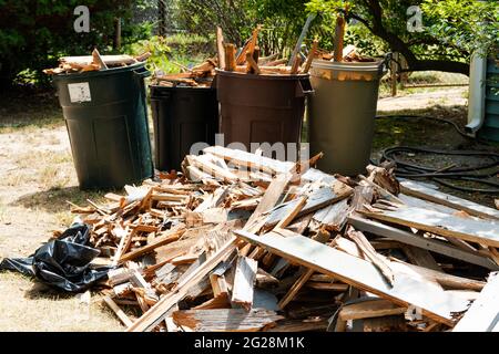 Des piles de bois sur le sol et dans les seaux à ordures laissés pour enlever une terrasse en bois dans une cour arrière. Banque D'Images