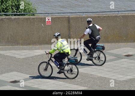 Deux policiers de Newham MPS en patrouille à vélo visitant Gallions point dans la région des Royal Docks de Londres Banque D'Images