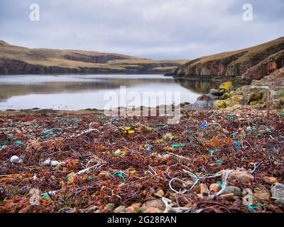 Les déchets de plastique et la pollution se sont enlais sur la plage reculée de South Ham sur le Mockle Roe à Shetland, au Royaume-Uni Banque D'Images