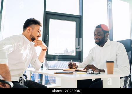 Deux employés de bureau multiraciaux tiennent une réunion dans le bureau Banque D'Images