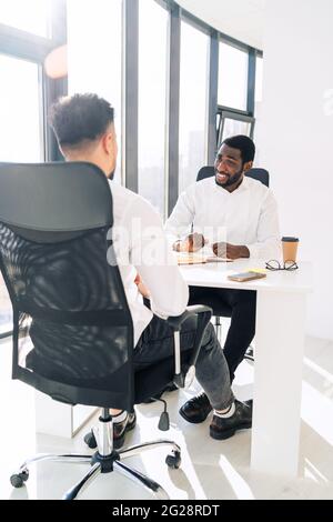 Deux employés de bureau multiraciaux au briefing du matin Banque D'Images