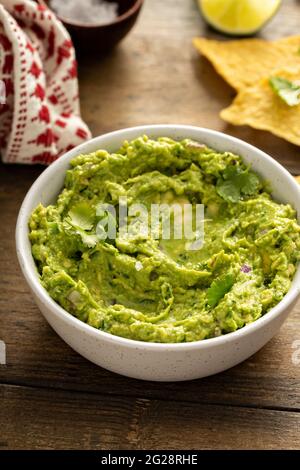 Gros guacamole maison dans un bol avec des chips de tortilla Banque D'Images