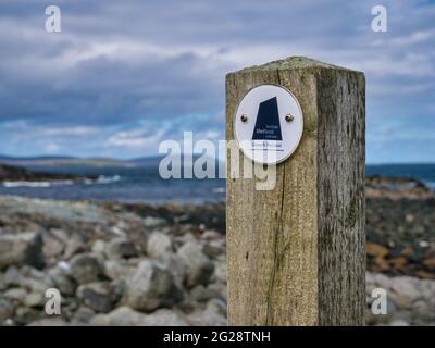 Panneau Geopark Shetland fixé à un poste en bois sur la côte est de Muness sur l'île d'Unst, Shetland, Royaume-Uni Banque D'Images