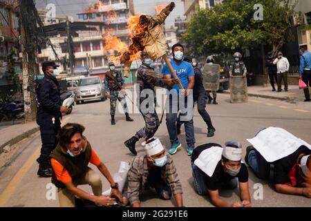 Katmandou, Népal. 9 juin 2021. Le personnel de police tente d'éveiller une effigie du Premier ministre du Népal, KP Sharma Oli, incendiée par l'alliance de l'opposition lors d'une manifestation contre la dissolution du Parlement, le remaniement ministériel et des élections anticipées dans le cadre du confinement de la pandémie du coronavirus à Katmandou, au Népal. Crédit: Skanda Gautam/ZUMA Wire/Alay Live News Banque D'Images