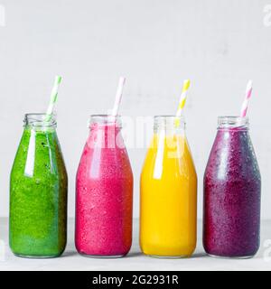 Smoothie coloré dans des bouteilles en verre. Smoothies aux fruits d'été en pots. Concept alimentaire sain et détox. Banque D'Images