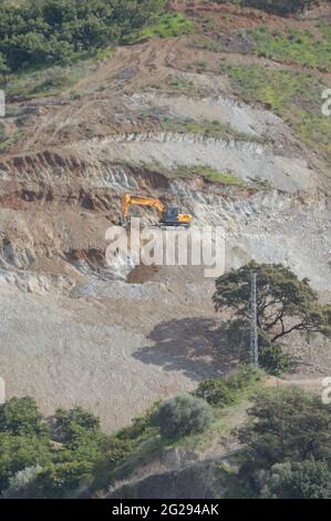 Pelle hydraulique de bulldozer travaillant sur un flanc de montagne Banque D'Images