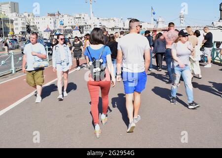Beaucoup de gens marchent à côté de Brighton Pier UK par une journée ensoleillée. Banque D'Images
