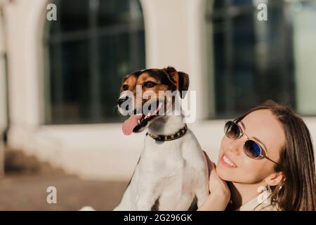 Une belle femme et son chien (parson russell terrier) posant les rues de la ville de шт Banque D'Images