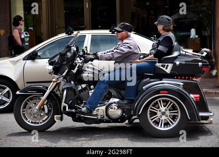 Un couple senior fait un tour de Harley-Davidson Trike Tri-Glide à travers la place historique de Santa Fe, Nouveau-Mexique. Banque D'Images