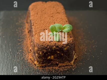 Gâteau au chocolat brun avec biscuits sur l'assiette noire Banque D'Images