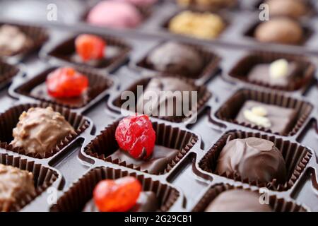 Bonbons au chocolat dans une boîte cadeau. Assortiment de bonbons aux fruits à coque et aux baies Banque D'Images