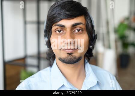 Portrait en gros plan d'un employé de soutien indien portant un casque sans fil, d'un homme de course mixte amical de l'est dans un élégant maillot décontracté regarde l'appareil photo, photo de l'agent de centre d'appel hindou Banque D'Images