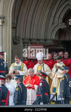 La GRC fait sortir le cercueil de Flaherty de la cathédrale et le ramène dans la voiture. Le cardinal Thomas Collins est sur la photo. Scènes de l'État funéraire pour Jim Banque D'Images