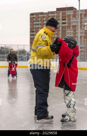 Les membres de la police de Toronto participent à l'ouverture officielle de la patinoire Regent Park; ils ont servi la communauté à aider les enfants à apprendre le ski de patinage Banque D'Images