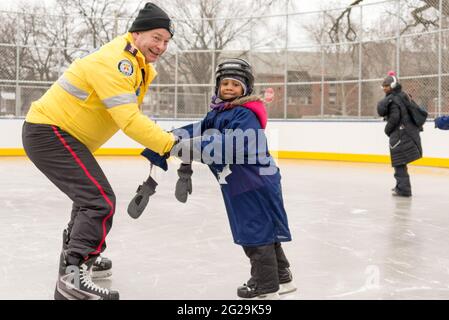 Les membres de la police de Toronto participent à l'ouverture officielle de la patinoire Regent Park; ils ont servi la communauté à aider les enfants à apprendre le ski de patinage Banque D'Images