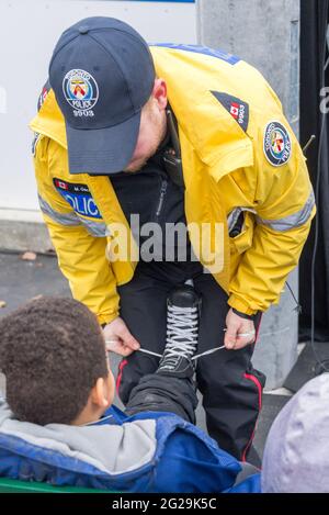 Les membres de la police de Toronto participent à l'ouverture officielle de la patinoire Regent Park; ils ont servi la communauté à aider les enfants à apprendre le ski de patinage Banque D'Images