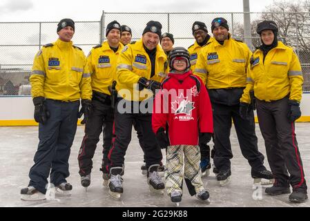 Les membres de la police de Toronto participent à l'ouverture officielle de la patinoire Regent Park; ils ont servi la communauté à aider les enfants à apprendre le ski de patinage Banque D'Images