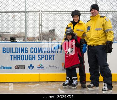 Les membres de la police de Toronto participent à l'ouverture officielle de la patinoire Regent Park; ils ont servi la communauté à aider les enfants à apprendre le ski de patinage Banque D'Images