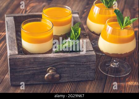 Cheesecake à la mangue servi dans les verres sur fond rustique Banque D'Images