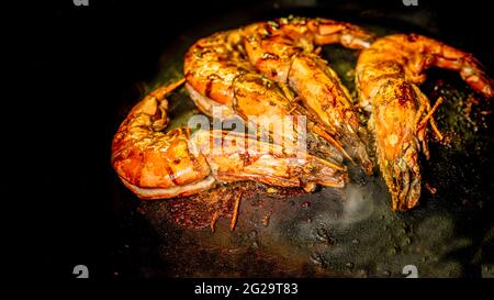 Crevettes grillées dans une poêle sur fond sombre. Hors-d'œuvre de fruits de mer. Repas délicieux. Banque D'Images