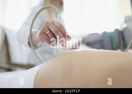 Médecin effectuant un examen échographique du fœtus de la femme enceinte en clinique de près Banque D'Images