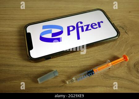 KONSKIE, POLOGNE - 9 juin 2021 : logo de la société Pfizer Inc affiché sur un téléphone portable avec une seringue. Concept du vaccin Covid-19 Banque D'Images