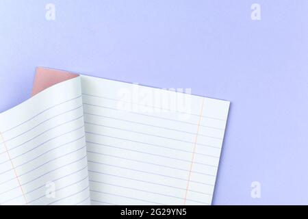 Carnet doublé ouvert pour l'école sur un fond violet pastel de bureau de table, espace de copie et vue de dessus Banque D'Images