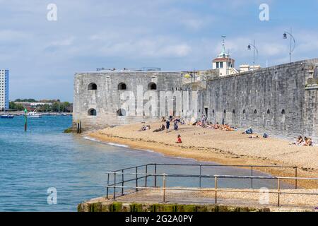 Bains de soleil sur la plage de galets en profitant du soleil à Hotmurals, une partie de point Battery et de la caserne sur le Vieux Portsmouth, Hampshire, côte sud de l'Angleterre Banque D'Images