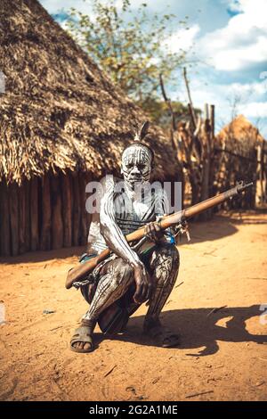 Homme avec corps peint tenant un fusil de chasse dans le village de la tribu Karo. Omo Valley, Éthiopie Banque D'Images