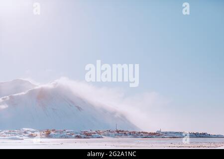 Vent violent soufflant de la neige des sommets de montagne contre un ciel sans nuages le jour d'hiver en Islande Banque D'Images