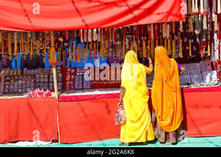 Couple de femmes non identifiées dans la traditionnelle hindou de porter saree achat ou shopping bijoux articles dans la rue commerciale de Pushkar foire dans l'état de Ra Banque D'Images