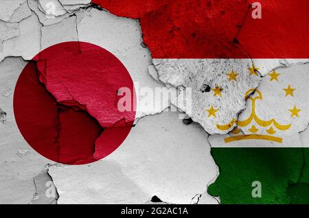 Drapeaux du Japon et du Tadjikistan peints sur un mur fissuré Banque D'Images