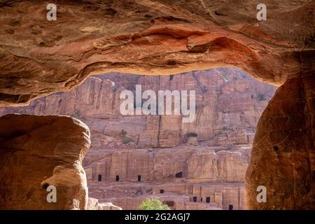 Vue de la rangée de formation de grès avec des tombes à travers l'entrée de la tombe, site archéologique de Petra, Jordanie Banque D'Images