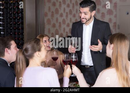 Beau homme prononçant des toasts au restaurant Banque D'Images