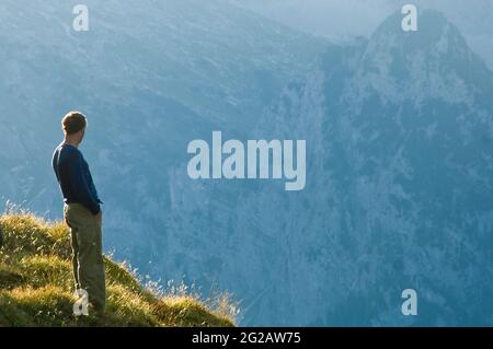 Homme prenant le soleil en soirée dans la haute région alpine Banque D'Images