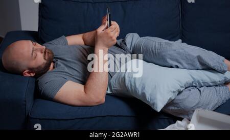 Triste malheureux malheureux déprimé choqué homme déprimant naviguant sur smartphone, luttant avec la santé mentale passant par une dépression majeure. Frustré et contrarié, un homme lisant un avis d'expulsion numérique Banque D'Images