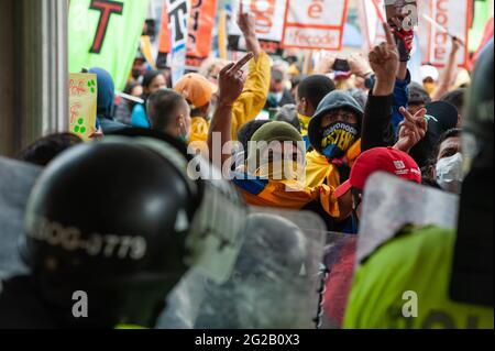 Bogota, Colombie. 9 juin 2021. Un manifestant se retourne le doigt à la police alors que des manifestations ont pris l'entrée de l'hôtel Tequendama lors des réunions de vérification des Nations Unies et de la CIDH dans le cadre de manifestations antigouvernementales en Colombie qui ont conduit à au moins 70 morts dans des brutalités policières et des troubles lors de manifestations d'un mois, le 9 juin. 2021 à Bogota, Colombie. Crédit : long Visual Press/Alamy Live News Banque D'Images