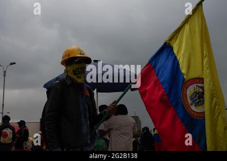 Bogota, Colombie. 9 juin 2021. Un manifestant porte un drapeau colombien alors que les manifestations se sont transformées en affrontements dans le sud de Bogota à Portal de las Americas, ce que les manifestants appellent « Portal Resistencia » au début de la 6e semaine de manifestations antigouvernementales contre la réforme fiscale et sanitaire du président Ivan Duque, l'égalité dans le pays et la brutalité policière. Le 9 juin 2021 à Bogota, Colombie crédit: Long Visual Press/Alamy Live News Banque D'Images