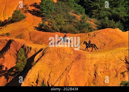 FRANCE, PROVENCE-ALPES-CÔTE D'AZUR. VAUCLUSE (84) RUSTEL, PARC NATIONAL DU LUBERON, ÉQUITATION DANS D'ÉTRANGES COLLINES DE SABLE APPELÉES COLORADO PROVENÇAL Banque D'Images