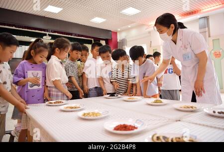 Donghai, Donghai, Chine. 10 juin 2021. Le 9 juin 2021, dans la troisième école maternelle du comté de Donghai, dans la ville de Lianyungang, dans la province de Jiangsu, un professeur de soins de santé enseigne aux enfants la phytothérapie chinoise. Le même jour, la troisième école maternelle du comté de Donghai, dans la ville de Lianyungang, dans la province de Jiangsu, a organisé des enfants pour mener à bien l'activité « apprendre au sujet du festival des bateaux-dragons et reconnaître la médecine chinoise ». Nous avons ressenti le charme de la médecine traditionnelle chinoise à l'approche du Dragon Boat Festival. Crédit : SIPA Asia/ZUMA Wire/Alay Live News Banque D'Images