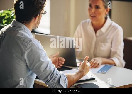 Homme assis à table pour un entretien d'emploi. Candidat masculin donnant un entretien d'emploi à un employeur en fonction. Banque D'Images