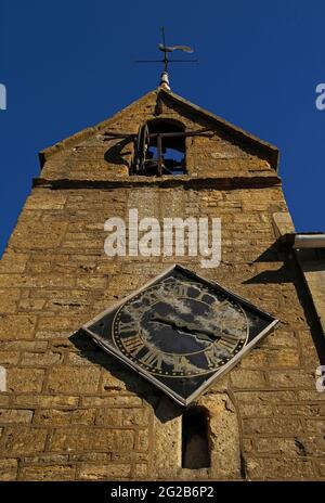 La tour de couvre-feu à pignons dans la ville de Moreton-in-Marsh, dans les Cotswold, dans le Gloucestershire, en Angleterre, au Royaume-Uni, date probablement du XVIe siècle et est une survie architecturale très rare. Il a une ancienne cellule de prison ou de prison à sa base, une horloge de 1648 et une cloche de couvre-feu de 1633 qui a été sonné tous les soirs jusqu’en 1860 pour avertir les résidents de « couvrir le feu » la nuit – essentiel dans un endroit où la plupart des maisons en pierre de couleur miel avaient des toits de chaume hautement inflammables. La tour se trouve à la jonction d'Oxford Street et High Street. Banque D'Images