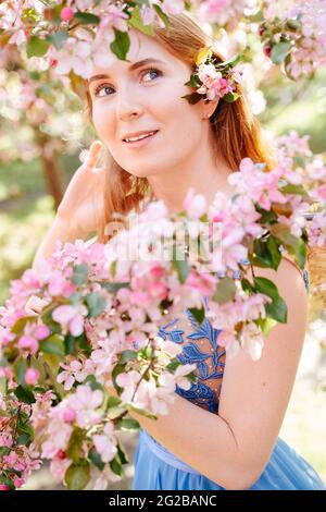 Bonne fille avec une branche d'un pommier en fleur. Banque D'Images