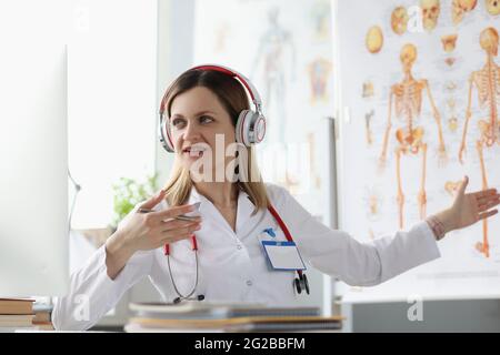 Femme médecin dans les écouteurs conduit la formation en ligne en médecine Banque D'Images