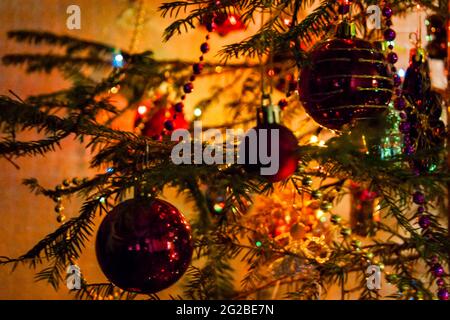 Nouvel an ou Noël en direct décoré avec élégance en épicéa gros plan - Jouets du nouvel an sur fond de branches vertes et feux Banque D'Images