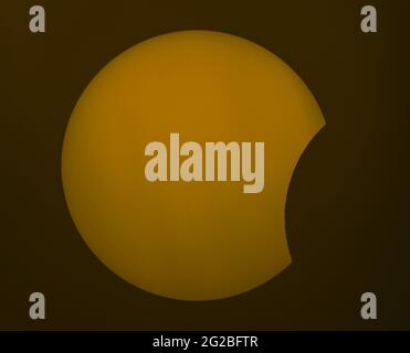 Londres, Royaume-Uni. 10 juin 2021. Image de l'éclipse solaire partielle comme la Lune quitte progressivement le disque du soleil. Il est possible de voir des montagnes lunaires sur le bord de la silhouette lunaire (en dessous du centre) et des groupes de taches solaires sont visibles sur la surface solaire. Image capturée à 11:58 grâce à une lentille à filtre solaire. Crédit : Malcolm Park/Alay Live News Banque D'Images