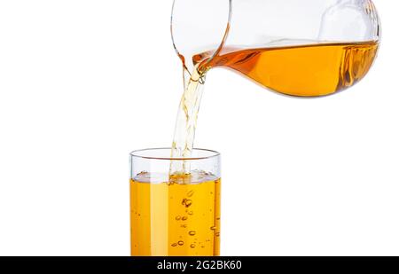 Jus de pomme et de raisin versé du pichet dans du verre isolé sur fond blanc Banque D'Images