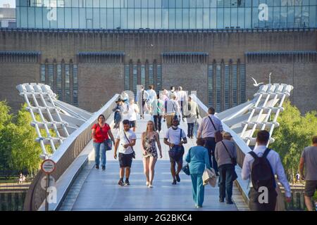 Les gens marchent le long du Millennium Bridge avec Tate Modern en arrière-plan, par une journée chaude et claire. Londres, Royaume-Uni 9 juin 2021. Banque D'Images