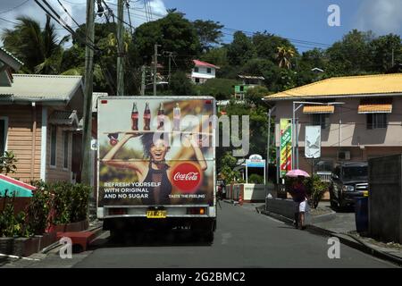 Victoria St Mark Grenada Street Scene Coca Cola livraison Van par Seventh Day Baptist Church and Woman Using Umbrella as parasol Banque D'Images