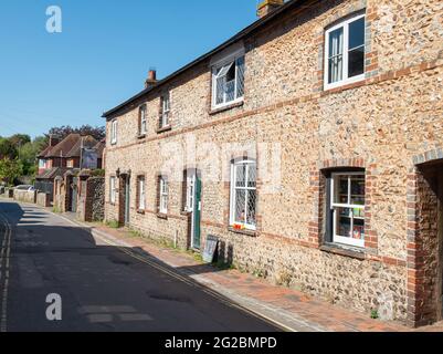 Bâtiment résidentiel construit en pierre d'époque sous le soleil d'été, contre un ciel bleu clair, à Alfriston, dans l'est du Sussex, en Angleterre. Banque D'Images